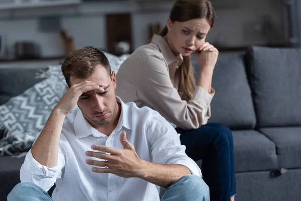 Pensive upset couple in living room at home — Stock Photo