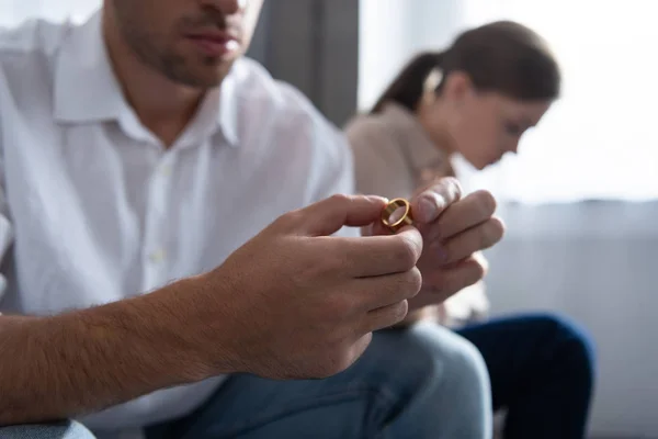 Vista recortada del hombre sosteniendo el anillo en las manos en casa - foto de stock