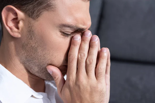 Депрессивный мужчина плачет в гостиной дома — стоковое фото