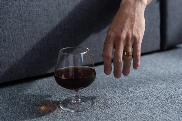 Partial view of man with ring and glass of cognac — Stock Photo