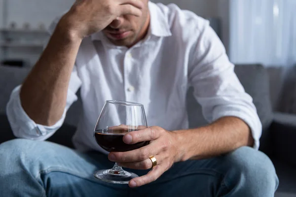 Vista parcial del hombre con anillo y cristal de coñac — Stock Photo