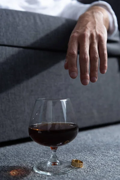 Partial view of man with ring and glass of cognac — Stock Photo