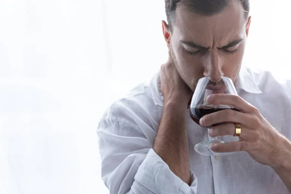 Front view of depressed man in shirt drinking cognac at home — Stock Photo