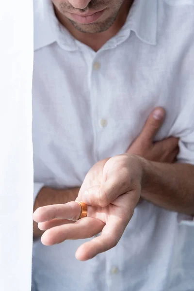 Vista parcial del hombre en camisa blanca con anillo en el dedo - foto de stock