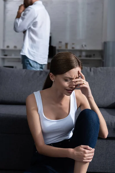 Chorando jovem mulher no sofá e homem de camisa branca — Fotografia de Stock