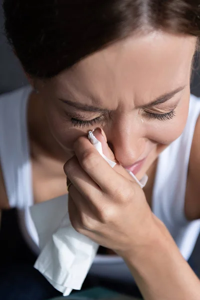 Sconvolto giovane donna piangendo e tenendo il tovagliolo a casa — Foto stock