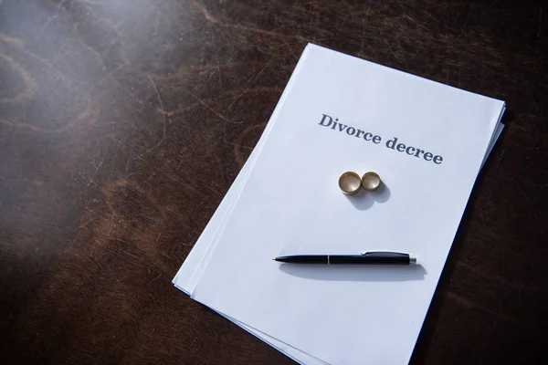Documentos de divorcio y pluma sobre mesa de madera marrón - foto de stock