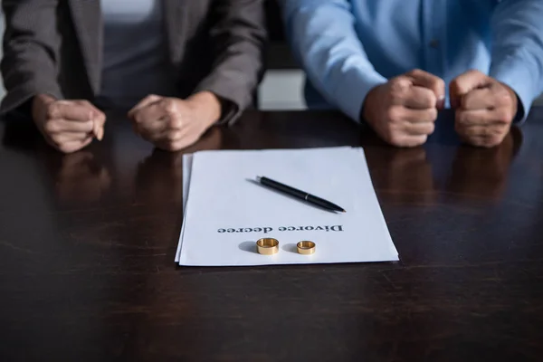 Частковий вид пари склеюючих кулаків за столом з документами розлучення — стокове фото