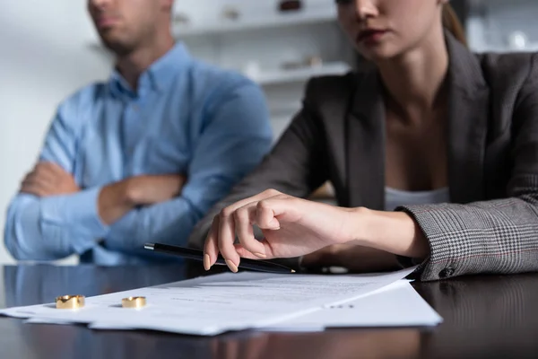 Vista parcial de la pareja en la mesa con documentos de divorcio - foto de stock