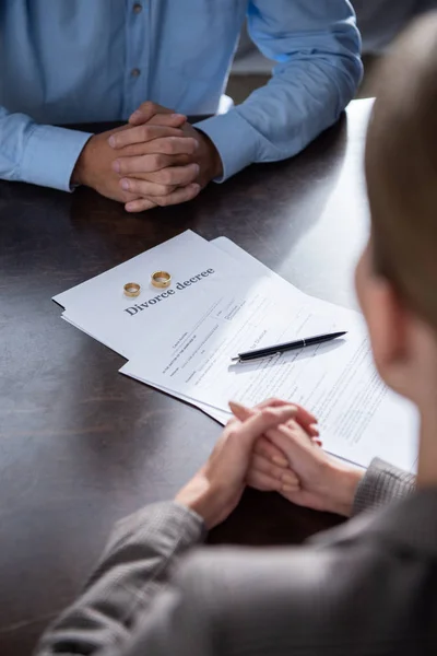 Vista parcial de la pareja en la mesa con documentos de divorcio - foto de stock