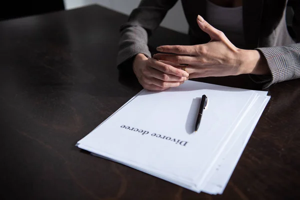 Vista parcial de la mujer con documentos de divorcio en la mesa - foto de stock