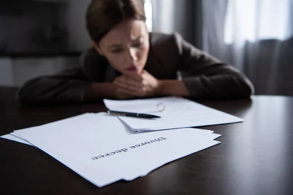Enfoque selectivo de la mujer triste en la mesa con documentos de divorcio - foto de stock