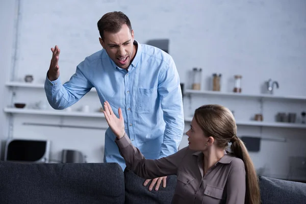 Homem agressivo na camisa gritando com a esposa durante a briga — Fotografia de Stock