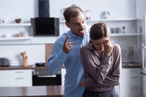 Homem agressivo na camisa gritando com chorando esposa durante briga — Fotografia de Stock