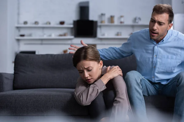 Donna sconvolta e uomo litigano a casa sul divano — Foto stock