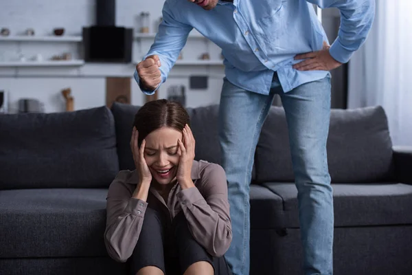 Partial view of man beating scared wife during quarrel — Stock Photo