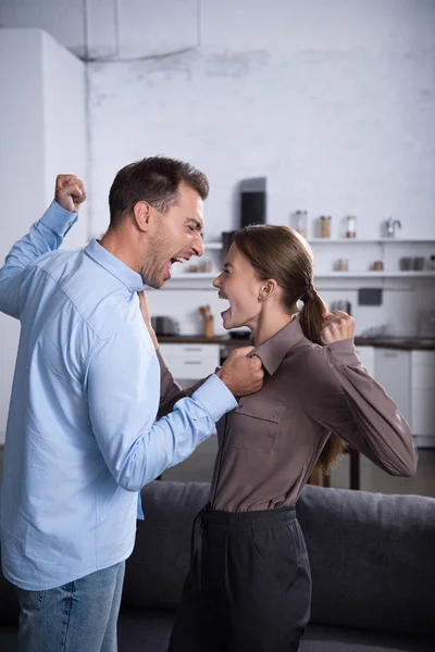 Enojados marido y mujer peleando y gritando el uno al otro - foto de stock