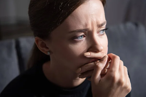 Bouleversé jeune femme couvrant la bouche avec la main et détournant les yeux — Photo de stock