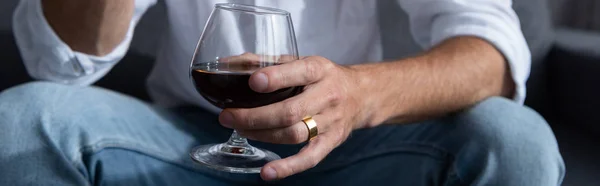 Tiro panorâmico de homem segurando copo de vinho com vinho tinto — Fotografia de Stock