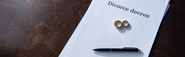 Coup panoramique de jugement de divorce, anneaux et stylo sur la table — Photo de stock