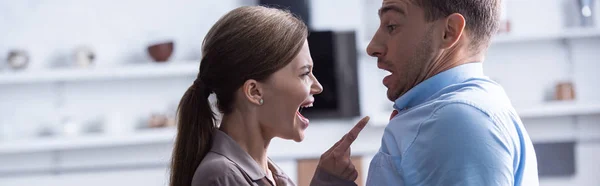Tiro panorâmico de mulher com raiva gritando com o marido assustado — Fotografia de Stock