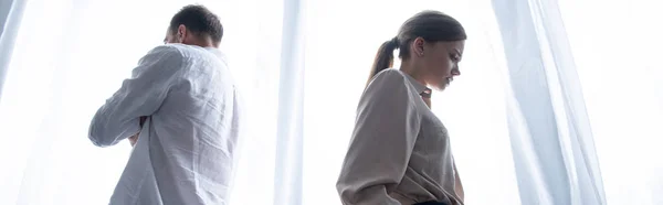 Panoramic shot of upset man and woman at home — Stock Photo