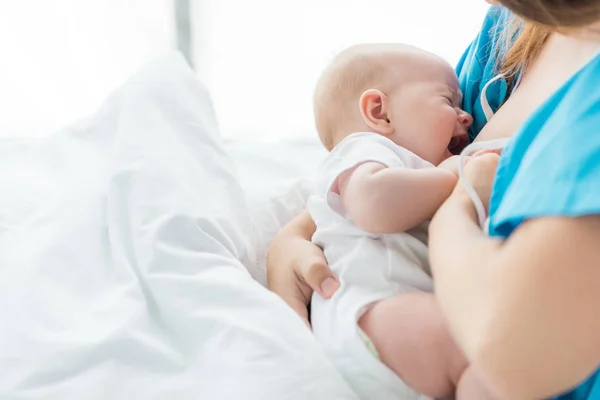 Обрезанный вид матери, кормящей грудью своего ребенка в больнице — стоковое фото