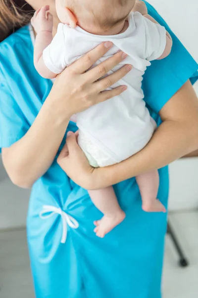 Vue recadrée de la jeune mère tenant son enfant à l'hôpital — Photo de stock
