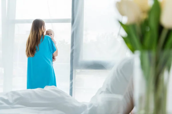 Focalizzazione selettiva della giovane madre che tiene il bambino in ospedale — Foto stock