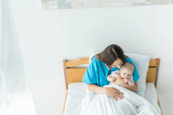 Vista ad alto angolo di giovane madre che tiene il bambino in ospedale — Foto stock