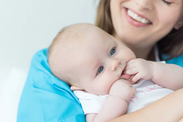 Ausschnitt einer jungen Mutter, die ihr Kind im Krankenhaus hält — Stockfoto