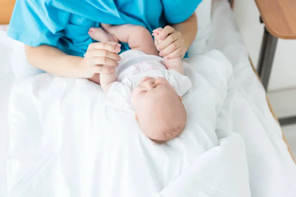 Vue recadrée de la jeune mère tenant son enfant à l'hôpital — Photo de stock