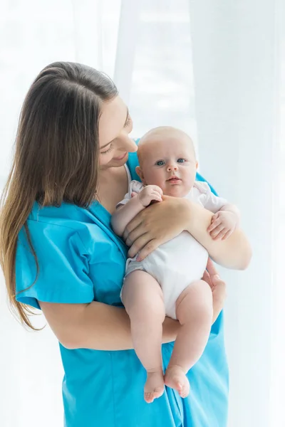 Attrayant et jeune mère tenant son enfant à l'hôpital — Photo de stock