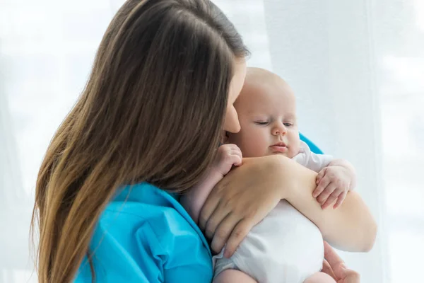 Young mother holding her cute child in hospital — Stock Photo