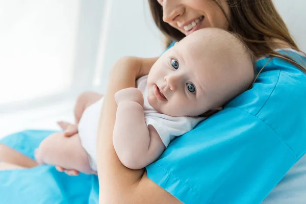 Cropped view of young mother holding her child in hospital — Stock Photo