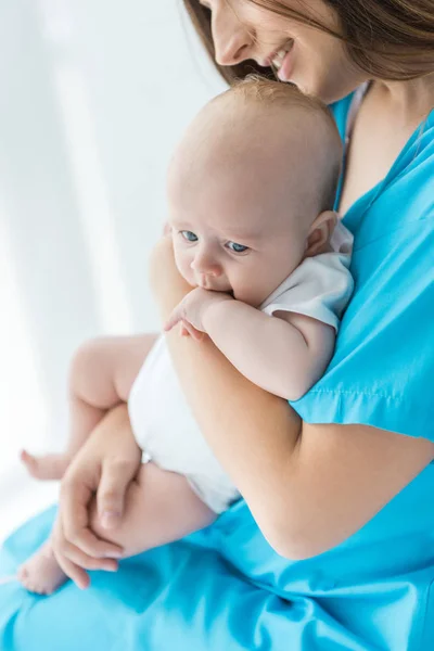 Cropped view of young mother holding her child in hospital — Stock Photo