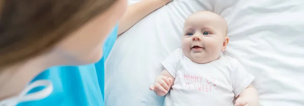 Panoramic shot of cute baby looking at mother in hospital — Stock Photo