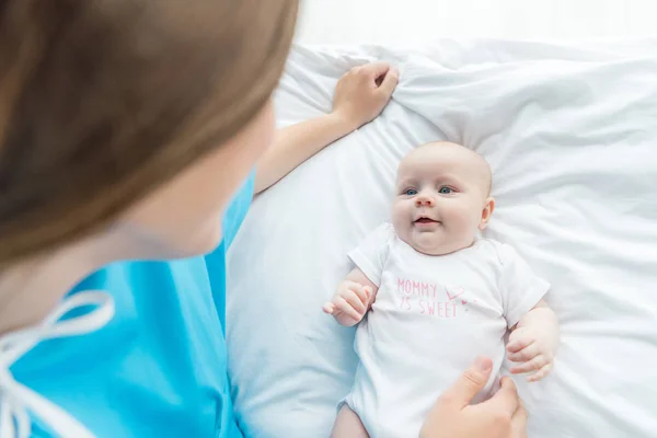 Высокий угол зрения симпатичного ребенка, смотрящего на мать в больнице — стоковое фото