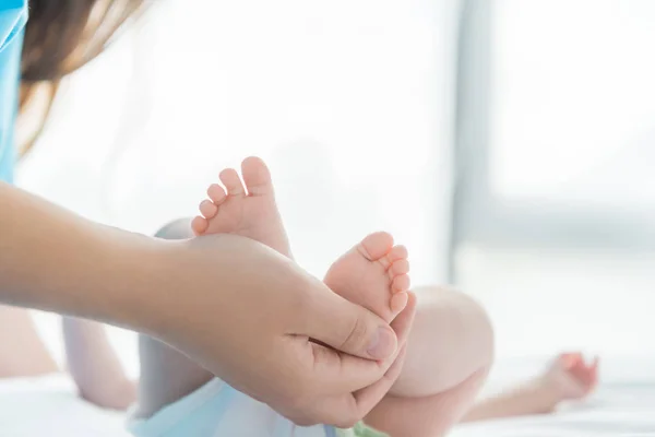 Ausgeschnittene Ansicht der Mutter, die Beine ihres Kindes hält — Stockfoto