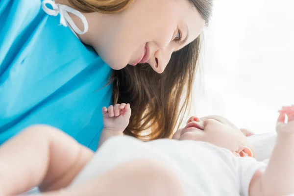 Foco seletivo da mãe atraente olhando para o bebê no hospital — Fotografia de Stock
