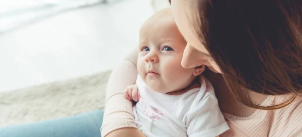 Panoramic shot of mother holding her child in apartment — Stock Photo