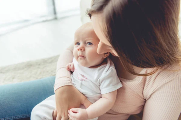 Vista ritagliata di madre che tiene il suo bambino in appartamento — Foto stock