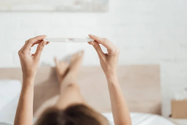 Partial view of young woman holding pregnancy test — Stock Photo