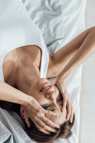 Overhead view of stressed young woman lying on bed at home — Stock Photo