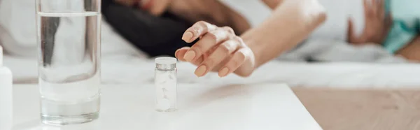 Plan panoramique de la femme avec des pilules et un verre d'eau — Photo de stock