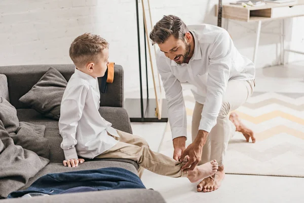 Sorrindo pai ajudando filho a se vestir em casa — Fotografia de Stock