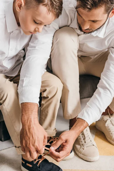 Father teaching son to tying shoelaces at home — Stock Photo