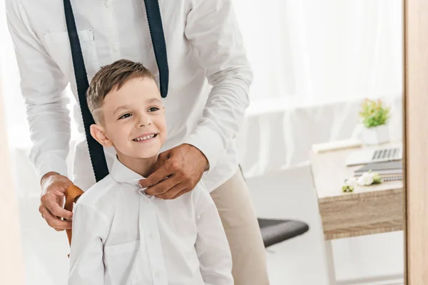 Vista parziale di padre e figlio in camicie bianche vestirsi vicino allo specchio — Foto stock