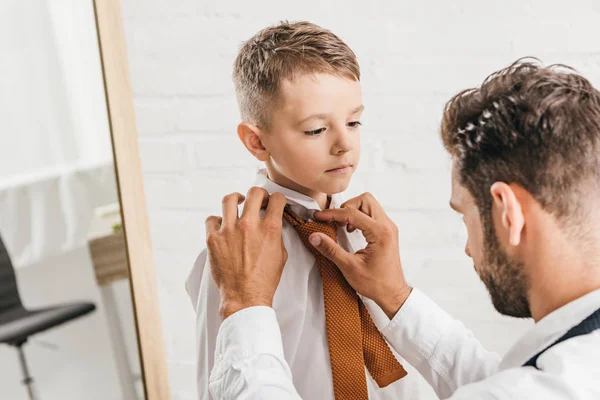 Father helping son to get dressed at home — Stock Photo