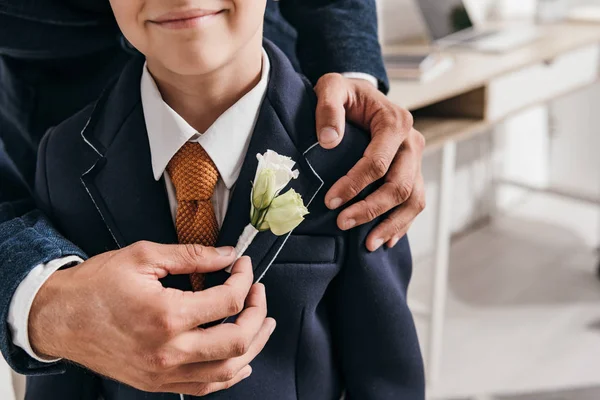 Cropped view of dad and son in jacket with boutonniere — Stock Photo